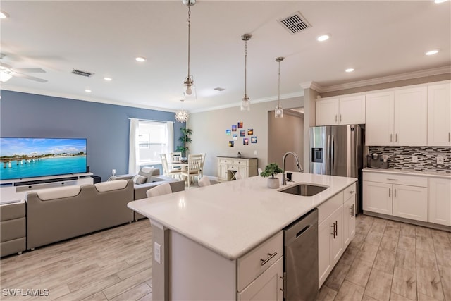 kitchen featuring visible vents, open floor plan, decorative backsplash, appliances with stainless steel finishes, and a sink