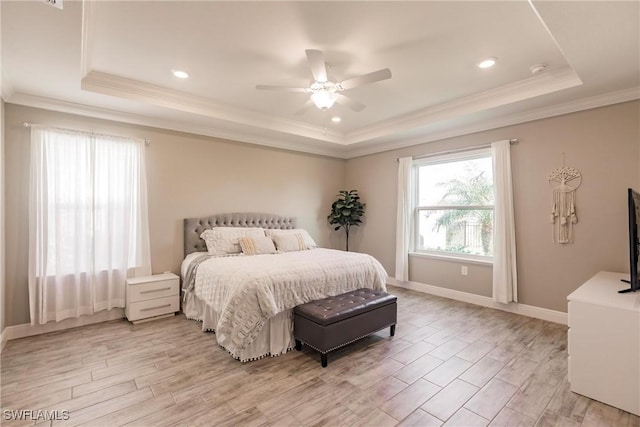 bedroom featuring a tray ceiling, baseboards, and light wood-type flooring