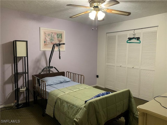 bedroom with a closet, a ceiling fan, dark colored carpet, baseboards, and a textured ceiling