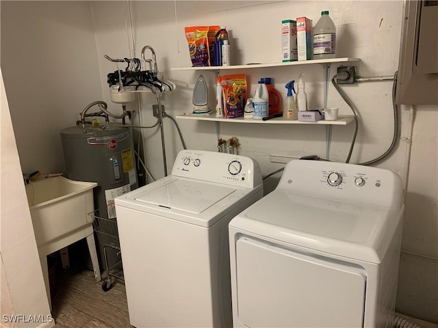 laundry room with laundry area, wood finished floors, washing machine and dryer, and water heater