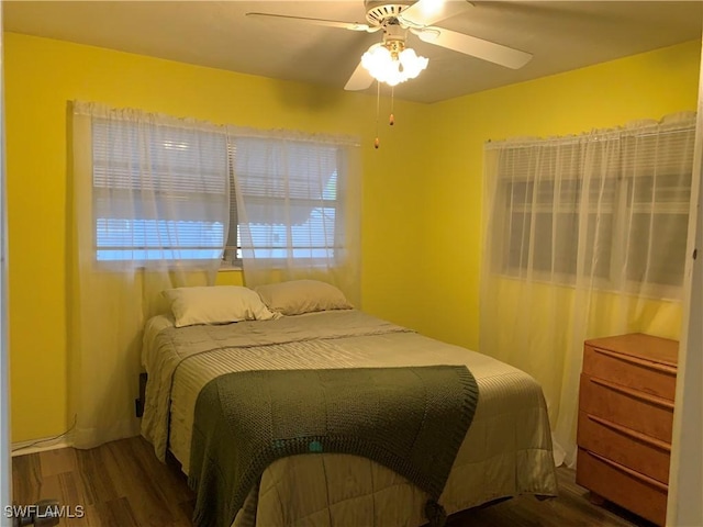 bedroom with wood finished floors, ceiling fan, and multiple windows