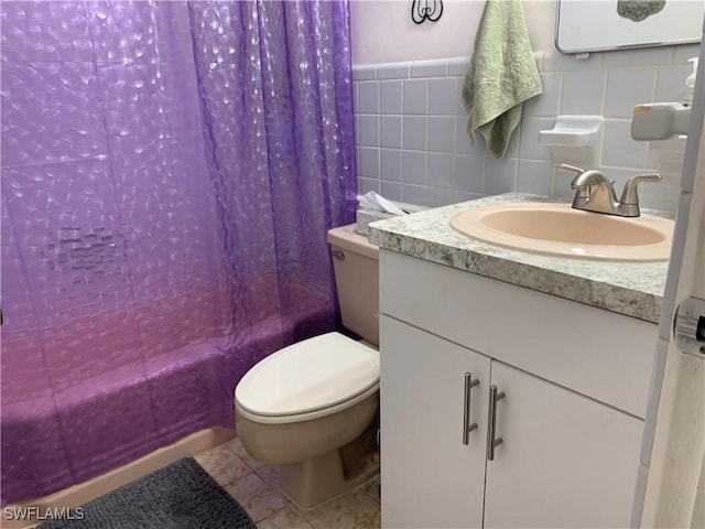 bathroom with tile walls, vanity, tile patterned floors, toilet, and shower / tub combo with curtain