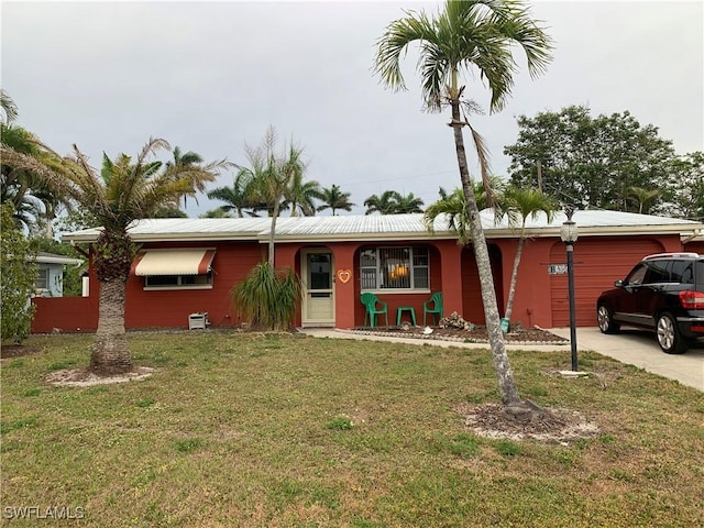 ranch-style house with a garage, concrete driveway, and a front lawn