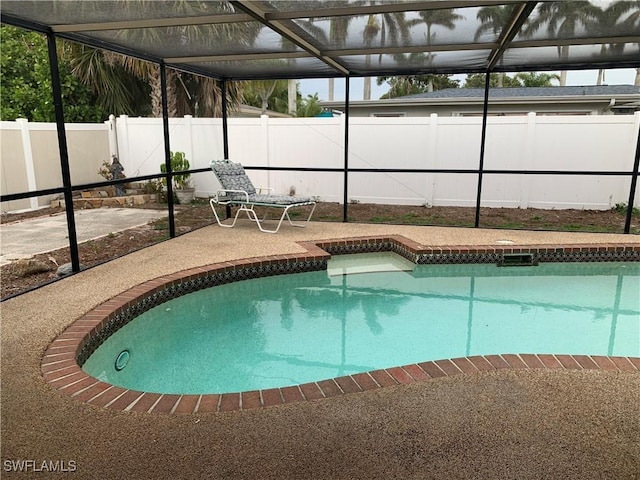 view of swimming pool featuring a lanai, a fenced in pool, a fenced backyard, and a patio area