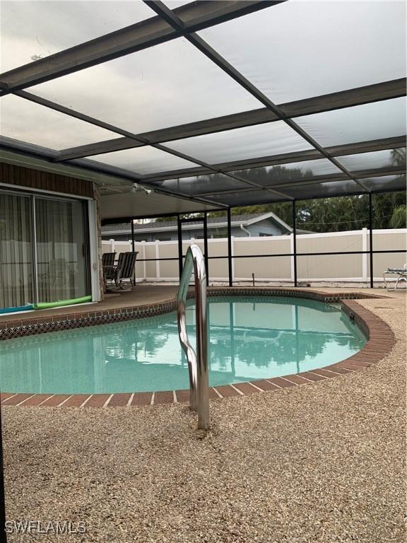 view of pool with a patio, a fenced backyard, a fenced in pool, and a lanai