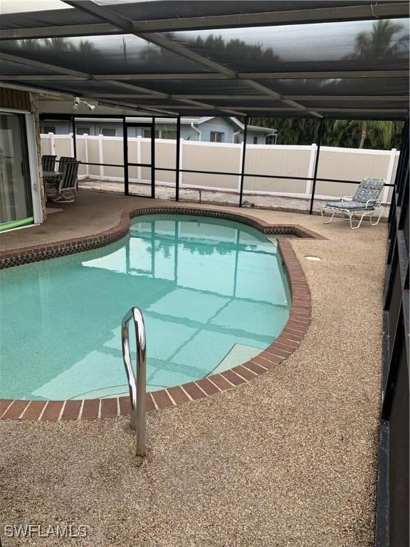 view of swimming pool with a patio, a fenced in pool, and a lanai