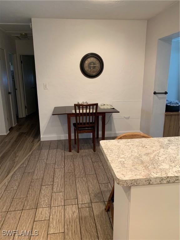 dining space featuring baseboards and wood tiled floor