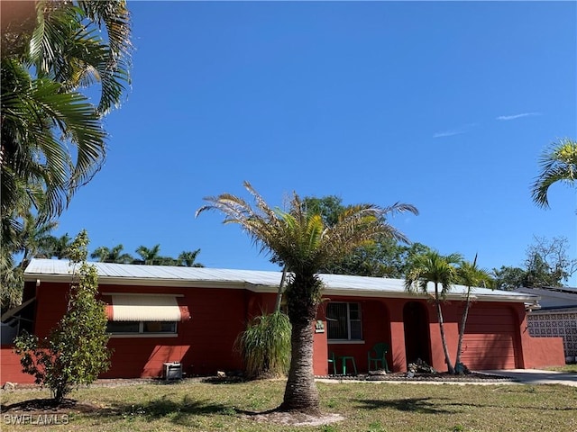 view of front of house with driveway, a front lawn, and an attached garage