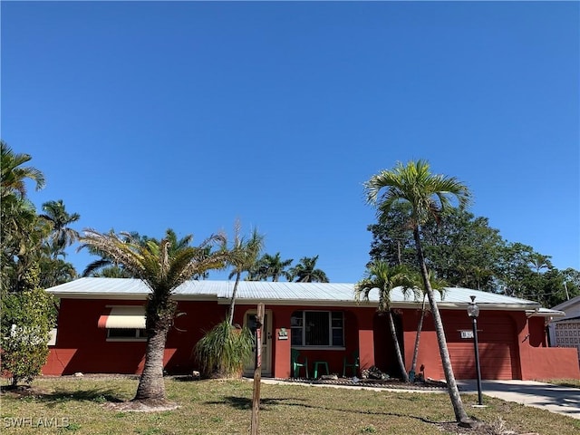 ranch-style house with a front yard, driveway, and an attached garage