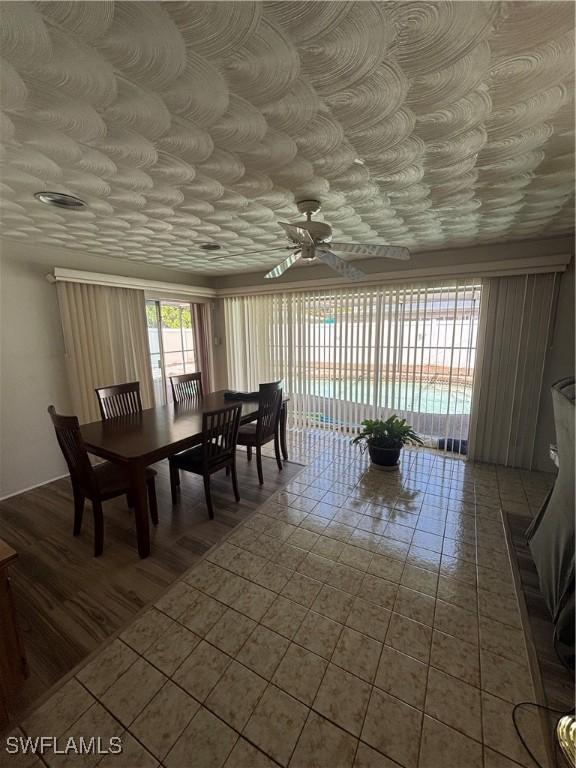 dining space with a ceiling fan and tile patterned floors