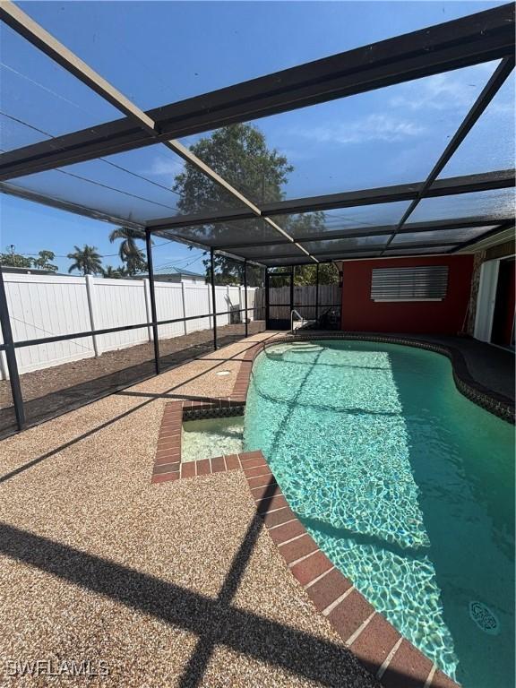 view of pool featuring a fenced in pool, a patio area, glass enclosure, and a fenced backyard