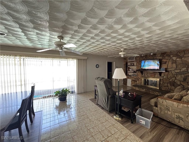 living room with a fireplace and ceiling fan