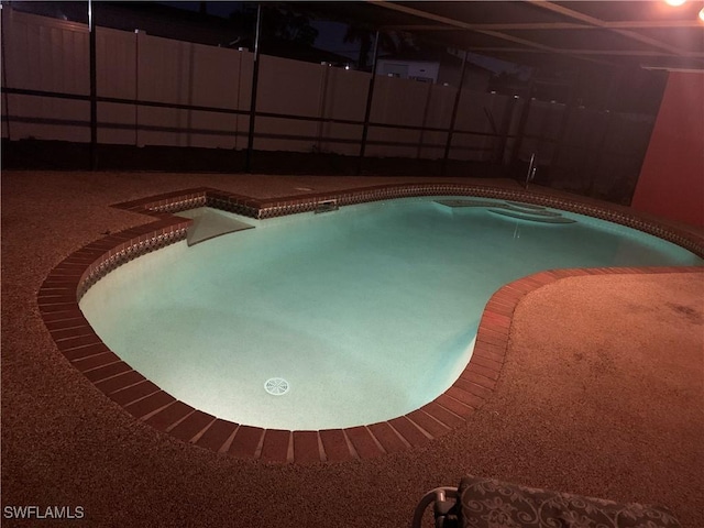 outdoor pool featuring fence and glass enclosure