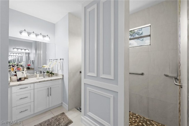 full bath featuring vanity, tile patterned floors, and a tile shower