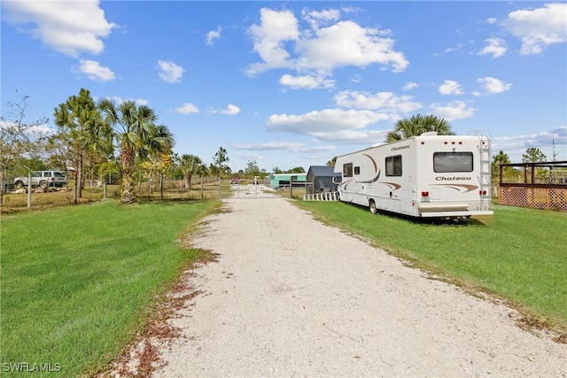 view of road featuring dirt driveway and a gated entry