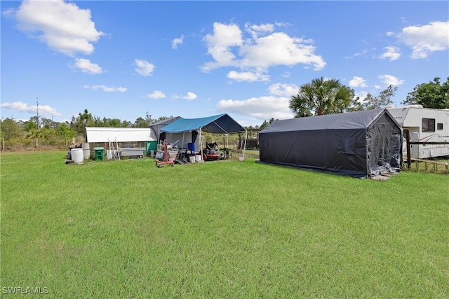 view of yard with a carport and an outdoor structure