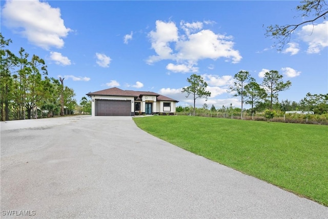 view of front facade with a front lawn, a garage, and driveway