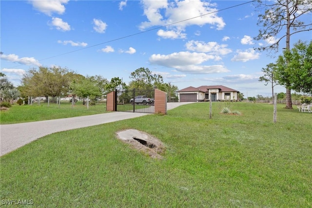 view of front of property with a garage, concrete driveway, a front lawn, and a gate