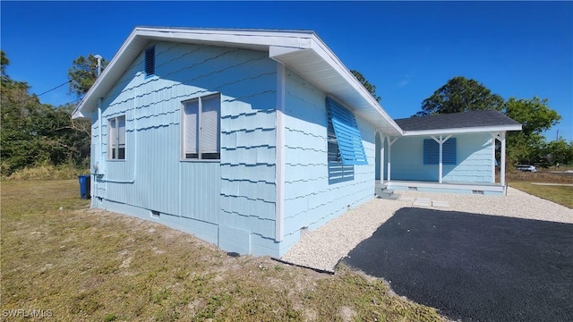 view of side of property with crawl space and a lawn