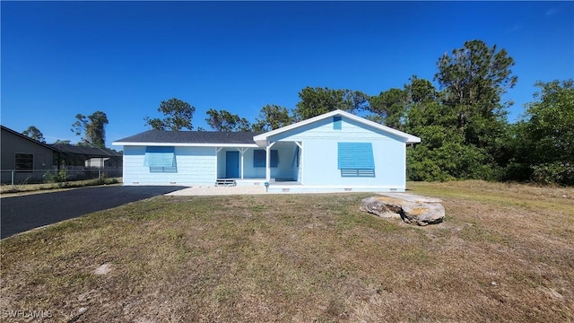 ranch-style home with driveway, a front yard, and fence