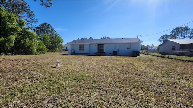 back of house with a lawn and fence