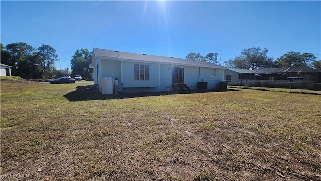 rear view of property with a lawn and fence