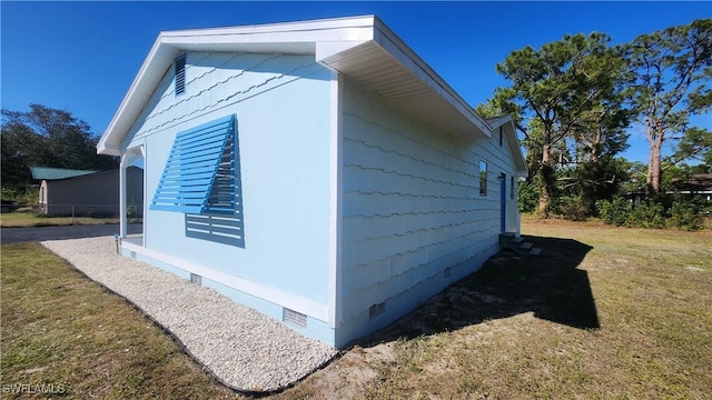 view of side of property featuring a yard and crawl space