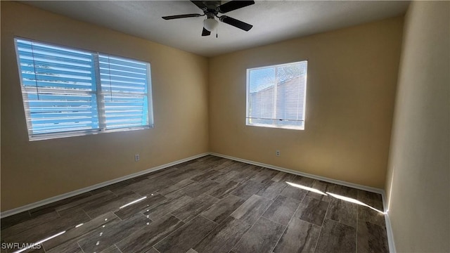 empty room featuring plenty of natural light, wood finish floors, and ceiling fan