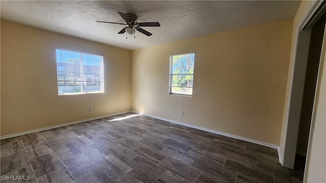 spare room featuring a textured ceiling, baseboards, and a ceiling fan