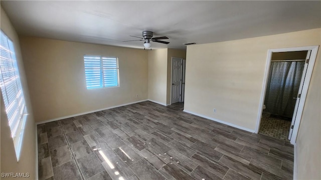 unfurnished room with visible vents, baseboards, ceiling fan, and wood tiled floor