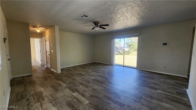 empty room with a textured ceiling, baseboards, visible vents, and ceiling fan