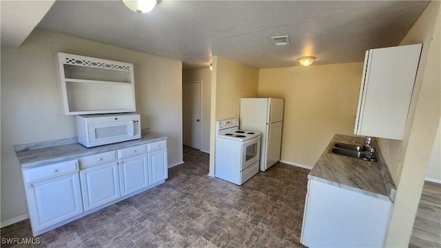 kitchen featuring visible vents, baseboards, white cabinets, white appliances, and a sink