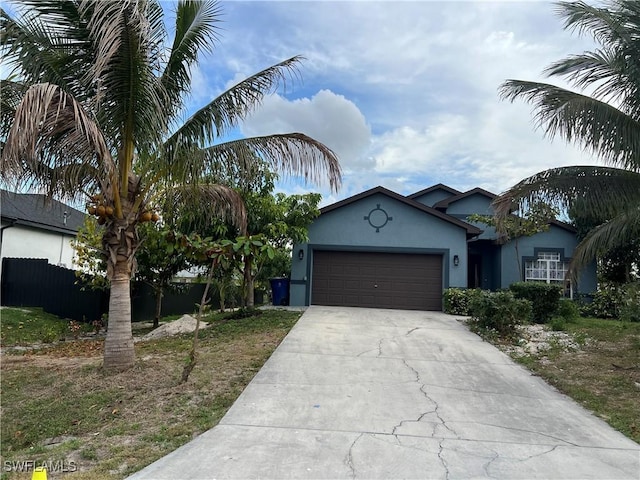 2609 4th St SW, Lehigh Acres, FL 33976 - single story home featuring fence, a garage, driveway, and stucco siding