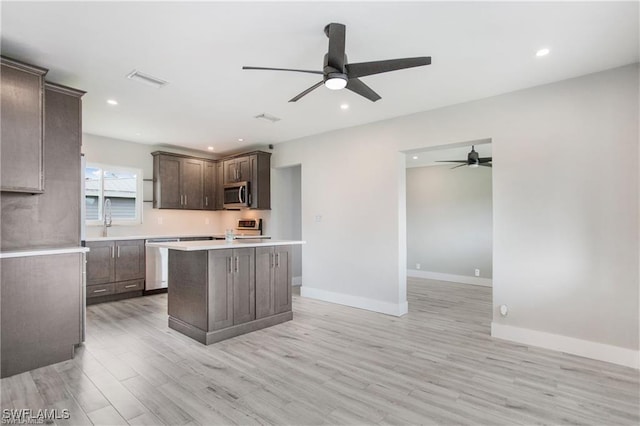 kitchen with light wood finished floors, dark brown cabinets, ceiling fan, light countertops, and stainless steel appliances