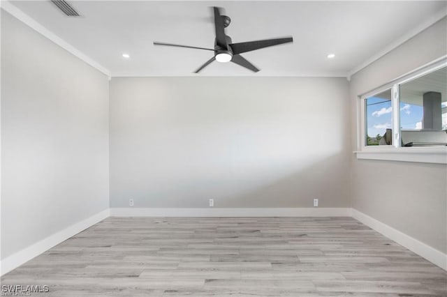 spare room featuring wood finished floors, baseboards, visible vents, and ceiling fan