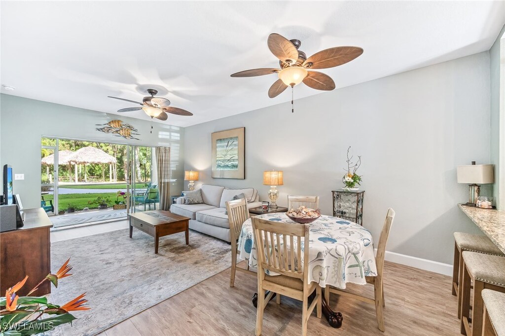 dining area featuring light wood-style floors, baseboards, and ceiling fan
