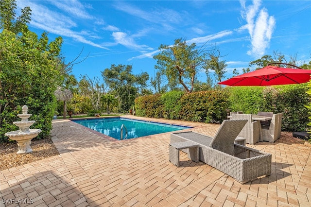 pool with outdoor dining area and a patio area