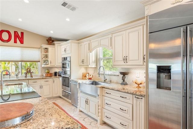 kitchen with a sink, visible vents, backsplash, and appliances with stainless steel finishes