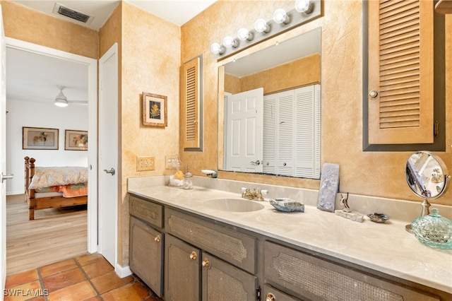 bathroom featuring ensuite bathroom, a closet, visible vents, ceiling fan, and vanity