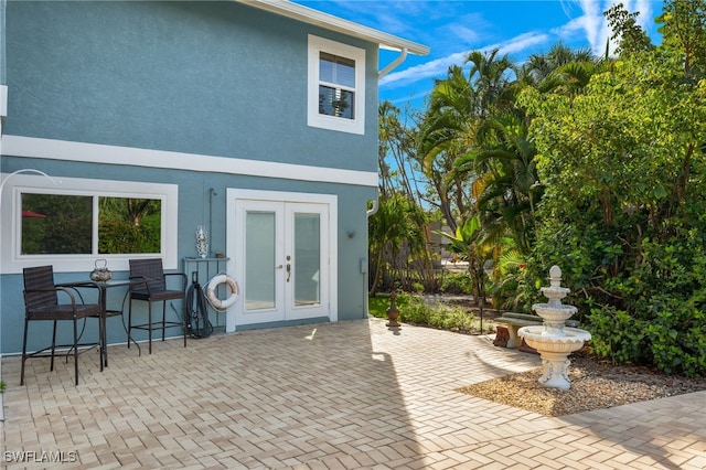 back of house with stucco siding, french doors, and a patio area