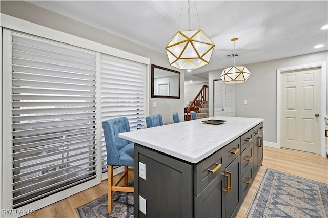 kitchen featuring visible vents, light wood finished floors, recessed lighting, pendant lighting, and a center island