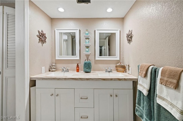 bathroom with a textured wall and a sink