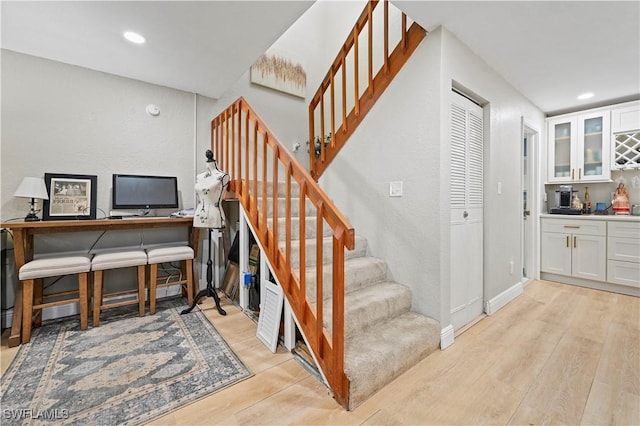 staircase with recessed lighting, wood finished floors, and baseboards