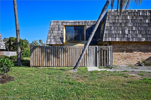 view of yard featuring a balcony and fence