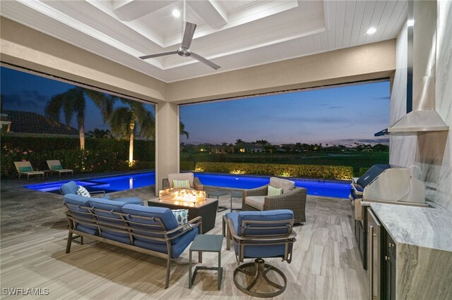 4150 Cortland Way, Naples, FL 34119 - patio terrace at dusk with an outdoor pool, ceiling fan, an outdoor living space with a fire pit, and exterior kitchen