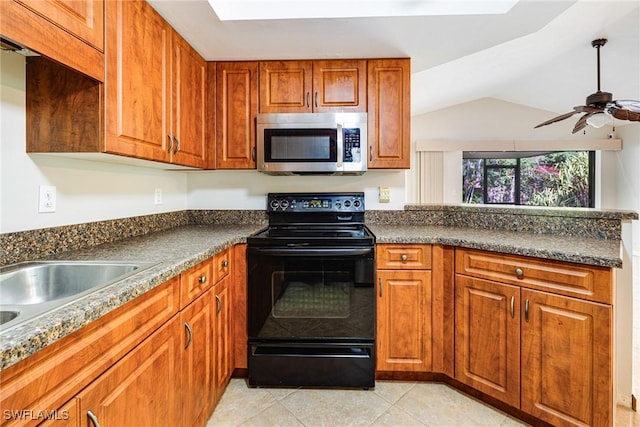 26955 Croise Dr, Bonita Springs, FL 34135 - kitchen featuring brown cabinetry, stainless steel microwave, dark countertops, and black / electric stove