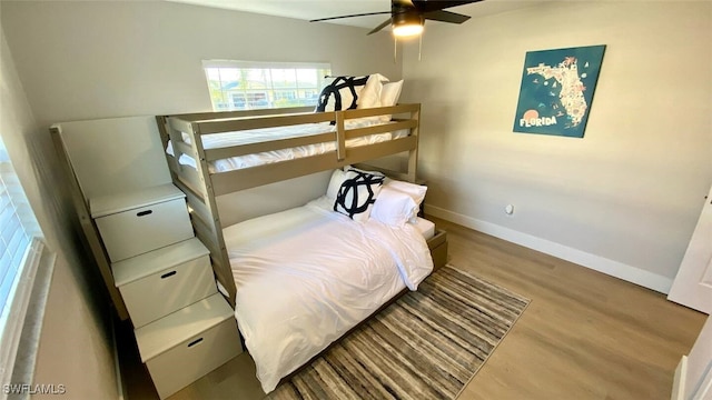 bedroom featuring wood finished floors, baseboards, and ceiling fan