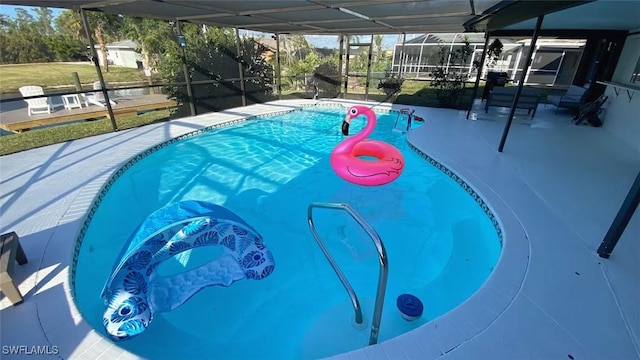 outdoor pool featuring glass enclosure and a patio area