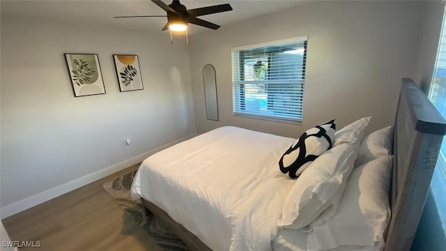 bedroom with ceiling fan, baseboards, and wood finished floors