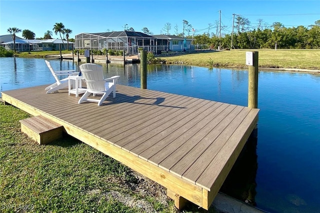 dock area with a water view and a lawn